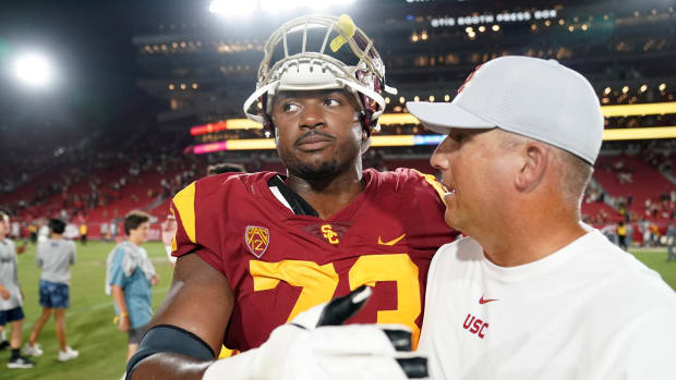Aug 31, 2019; Los Angeles, CA, USA; Southern California Trojans head coach Clay Helton (right) and offensive tackle Austin Jackson (73) embrace after the game against the Fresno State Bulldogs at Los Angeles Memorial Coliseum. USC defeated Fresno State 31-23.